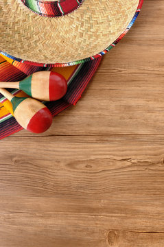 Mexican background serape striped blanket with sombrero maracas on wood wooden floor Mexico cinco de mayo festival vacation photo