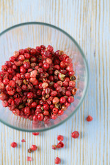 red peppercorns on wooden table