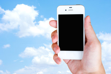 Smart phone in hand on blue sky background