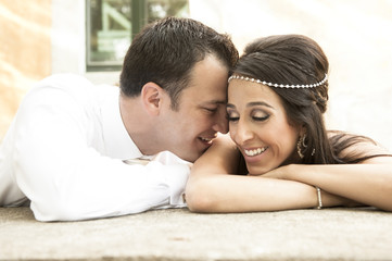 Happy young newly wed couple smiling and laughing outdoors