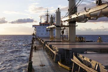 Cargo ship underway at sunset