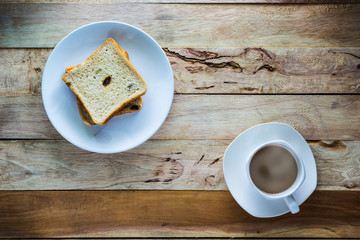 Hot coffee and Raisin Bread on wood table