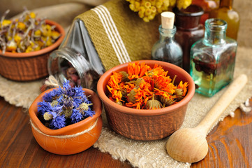 Healing herbs and tinctures in bottles on sackcloth