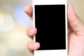 Smart phone in hand on bokeh background