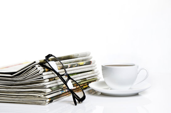 glasses and newspapers with a cup of coffee