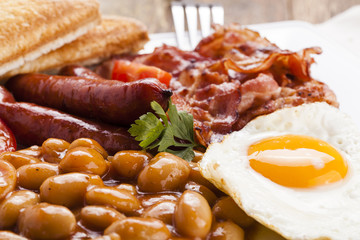 Full english breakfast with bacon, sausage, fried egg, baked bea