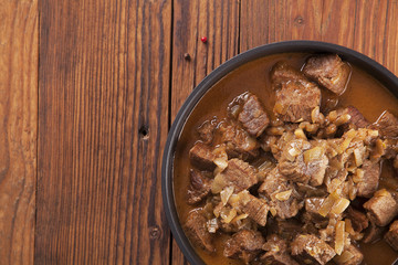 Beef stew - wooden background