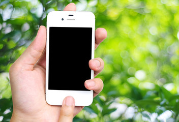 Smart phone in hand on blur tree with bokeh background