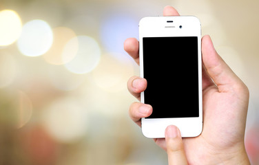 Smart phone in hand on bokeh background