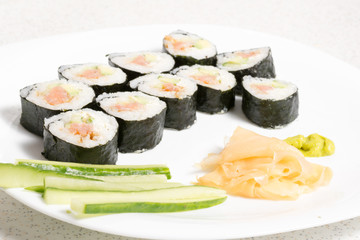 Homemade sushi in a white plate with wasabi and ginger