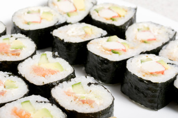 Homemade sushi in a white plate with wasabi and ginger