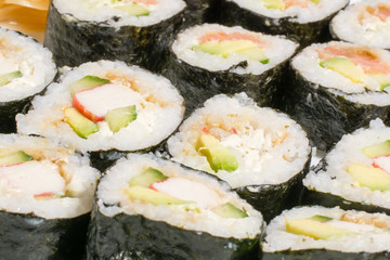 Homemade sushi in a white plate with wasabi and ginger
