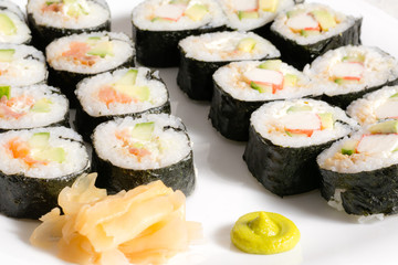 Homemade sushi in a white plate with wasabi and ginger