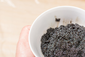 Fresh black caviar in a bowl to make sushi and fish dishes