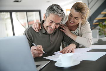 Fototapeta premium Couple calculating financial savings on internet
