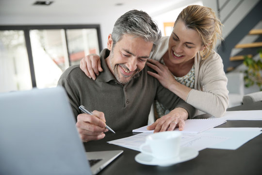 Couple calculating financial savings on internet