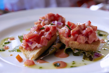 Onion and tomato bruschetta on fresh garden laid leaves