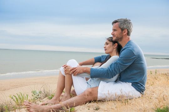 a beautiful couple is holding eachother at the beach