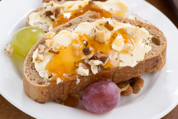 bread with butter, honey, nuts and grapes