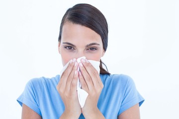 Sick woman blowing her nose