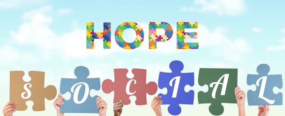 Composite image of hands holding up social jigsaw pieces