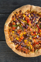 Homemade vegeterian pizza from above on wooden table