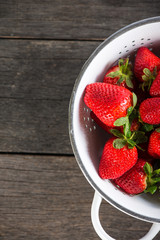 Fresh just clean wet strawberries in rustic colander
