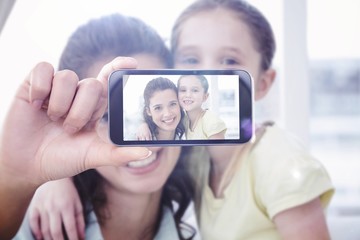 Composite image of hand holding smartphone showing