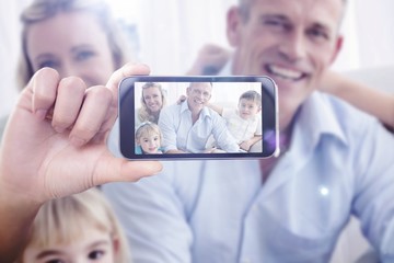 Composite image of hand holding smartphone showing