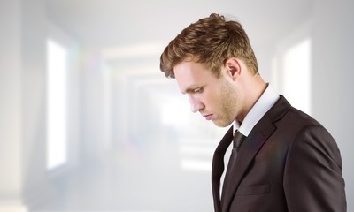 Fototapeta premium Composite image of young handsome businessman looking down