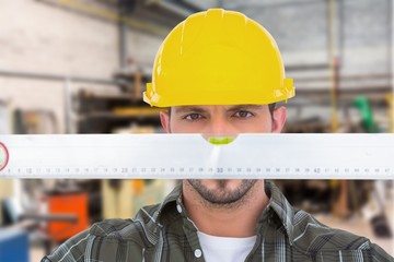 Composite image of handyman looking at spirit level