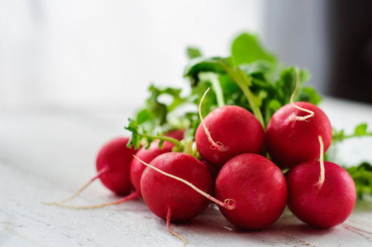Bunch of fresh radishes on white board