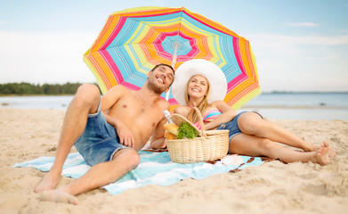couple having picnic and sunbathing on beach