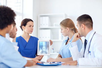 group of doctors with x-ray on tablet pc at clinic