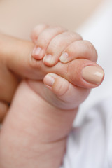 Close-up of baby's hand holding mother's finger