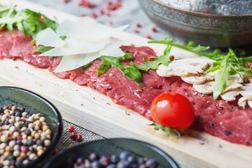 traditional dish of beef carpaccio on wooden plate