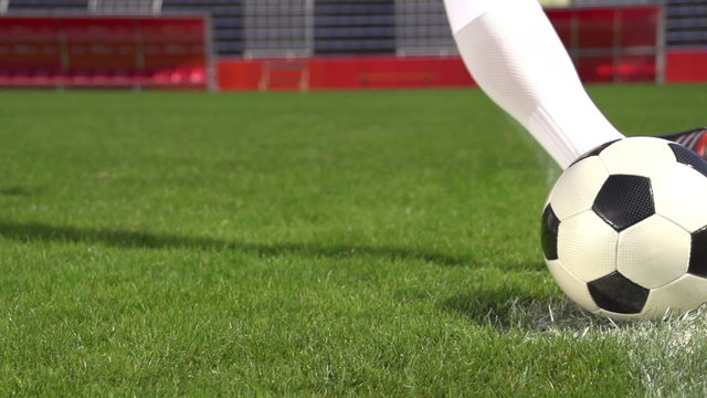 detail soccer player kicking ball on field slow motion
