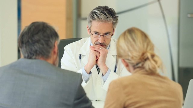 Doctor meeting couple in doctor's office