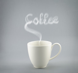 Cup of hot coffee with steam on gray background