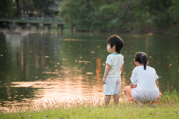 Cute little asian girl looking at the beautiful lake