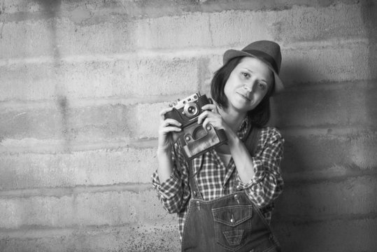 Indoor portrait of woman with vintage camera in a black and whit