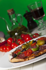 Pizza mit Zutaten auf Grün