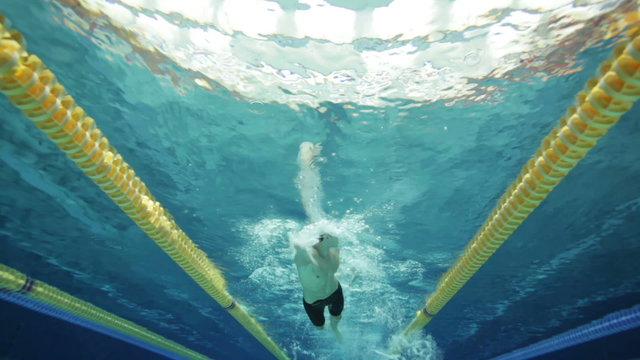 under water view male swimmer swimming front crawl in pool with swimming lanes