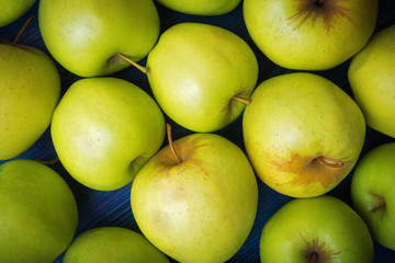 Green apples on blue wooden background