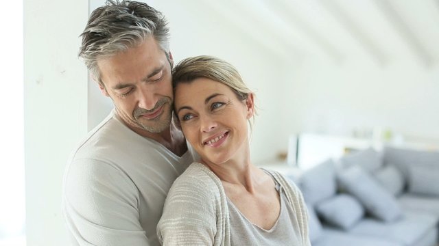 Mature couple embracing each other at home