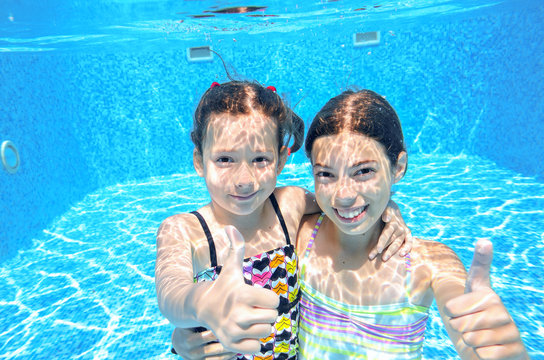 Children swim in pool underwater, girls swimming, kids sport