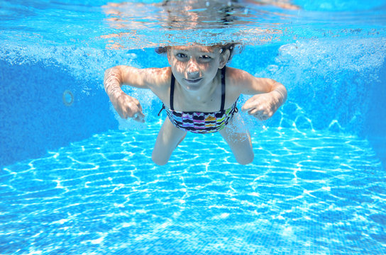 Girl swims in pool underwater, kid swimming, children sport