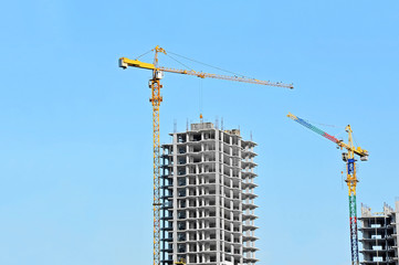 Crane and building construction site against blue sky