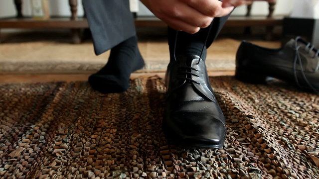 Man tying his black shoelaces