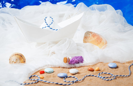 paper boat with sand, ropes, water